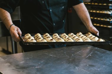 Fırınlanmamış ekmekle tepsiyi tutan tanınmamış bir adam. Geleneksel İtalyan mutfağı. Sicilya yemeği.