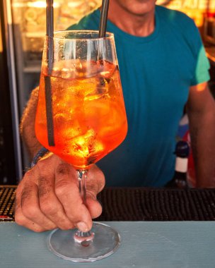 Spritz traditional cocktail with alcohol being prepared by unrecognizable man in a beach bar. European summer drink. Italian drink. Lifestyle concept