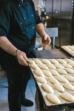 Fırınlanmamış ekmekle tepsiyi tutan tanınmamış bir adam. Geleneksel İtalyan mutfağı. Sicilya yemeği.