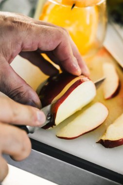 İçki süslemek için bar tezgahında elma kesen tanınmamış bir barmen.. 