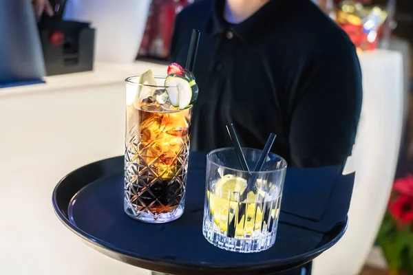 Tanınmayan garson tepside farklı içkiler servis etmeye hazır.