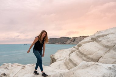 Scala dei Turchi, Agrigento, Sicilya, İtalya 'nın beyaz kireçtaşı uçurumlarına hayran olan bir turist. Türklerin Merdivenleri