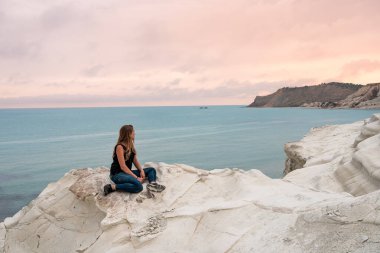 Scala dei Turchi, Agrigento, Sicilya, İtalya 'nın beyaz kireçtaşı uçurumlarına hayran olan bir turist. Türklerin Merdivenleri