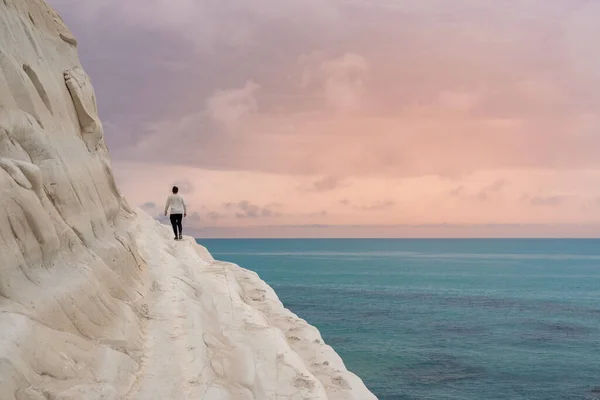 Genç adam Scala dei Turchi, Agrigento, Sicilya, İtalya 'nın beyaz kireçtaşı kayalıklarına hayran. Yüksek kalite fotoğraf