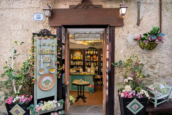 Eski bir Avrupa caddesinde renkli süslemeleri ve çiçekleri olan büyüleyici seramik sanat dükkânı