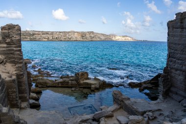 İtalya, Favignana 'da kaya yapıları ve berrak mavi suyu olan antik kıyı ocağı.