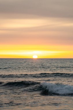 Parlayan günbatımı yansımaları turuncu ve kırmızı ile okyanus dalgalarına yakın çekim
