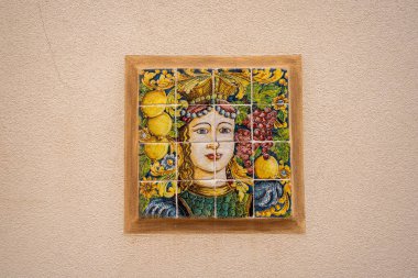 Renkli el yapımı seramik fayanslar. Meyve ve ve çiçeklerle taçlı bir kadın tasvir ediliyor.