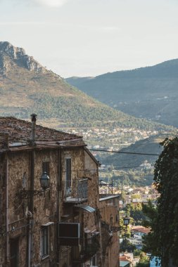 Sicilya 'da bir tepe kasabasında manzaralı dağ vadisine bakan eski taş binalar.