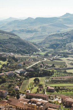 Gün batımında dağları ve ağaçları olan bir Sicilya köyü.