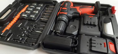 Elektrik kırmızı kablosuz tornavida matkabı. Şarjı beyaz arka planda izole edilmiş. Profesyonel ev onarım aleti. Bekasi, Batı Java, Endonezya - 17 Mayıs 2024