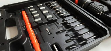 Elektrik kırmızı kablosuz tornavida matkabı. Şarjı beyaz arka planda izole edilmiş. Profesyonel ev onarım aleti. Bekasi, Batı Java, Endonezya - 17 Mayıs 2024