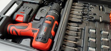 Elektrik kırmızı kablosuz tornavida matkabı. Şarjı beyaz arka planda izole edilmiş. Profesyonel ev onarım aleti. Bekasi, Batı Java, Endonezya - 17 Mayıs 2024