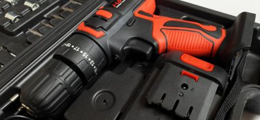 Elektrik kırmızı kablosuz tornavida matkabı. Şarjı beyaz arka planda izole edilmiş. Profesyonel ev onarım aleti. Bekasi, Batı Java, Endonezya - 17 Mayıs 2024