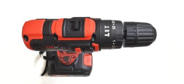 Elektrik kırmızı kablosuz tornavida matkabı. Şarjı beyaz arka planda izole edilmiş. Profesyonel ev onarım aleti. Bekasi, Batı Java, Endonezya - 17 Mayıs 2024