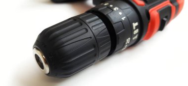 Elektrik kırmızı kablosuz tornavida matkabı. Şarjı beyaz arka planda izole edilmiş. Profesyonel ev onarım aleti. Bekasi, Batı Java, Endonezya - 17 Mayıs 2024