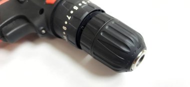 Elektrik kırmızı kablosuz tornavida matkabı. Şarjı beyaz arka planda izole edilmiş. Profesyonel ev onarım aleti. Bekasi, Batı Java, Endonezya - 17 Mayıs 2024