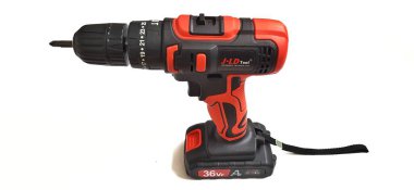 Elektrik kırmızı kablosuz tornavida matkabı. Şarjı beyaz arka planda izole edilmiş. Profesyonel ev onarım aleti. Bekasi, Batı Java, Endonezya - 17 Mayıs 2024