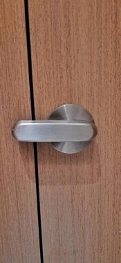 Ahşap duvar kapısına modern kapı kilidi takılı tuvalet bölmesi. Mahremiyet ve temizlik kavramı.