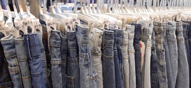 Pasar Senen 'de satılık bir askıda asılı duran kot pantolonun değişik çeşitleri. Jakarta, Endonezya