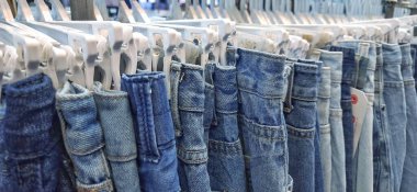 Pasar Senen 'de satılık bir askıda asılı duran kot pantolonun değişik çeşitleri. Jakarta, Endonezya