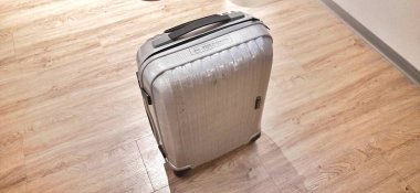 Otel odasının ahşap zemininde bavulu kapat. Seyahat konsepti. Jakarta, Endonezya - 23 Kasım 2024