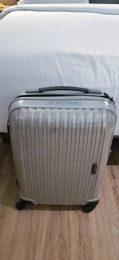 Otel odasının ahşap zemininde bavulu kapat. Seyahat konsepti. Jakarta, Endonezya - 23 Kasım 2024