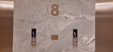 Üst ve alt asansör düğmeleri dokulu duvarda. Jakarta, Endonezya - 23 Kasım 2024