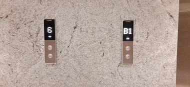 Üst ve alt asansör düğmeleri dokulu duvarda. Jakarta, Endonezya - 23 Kasım 2024