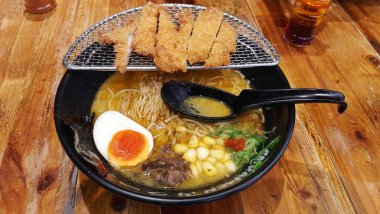 Sai Ramen Lokantası 'nda siyah bir kase körili tavuk katsu ramen eriştesi. Jakarta, Endonezya - 12 Mayıs 2025