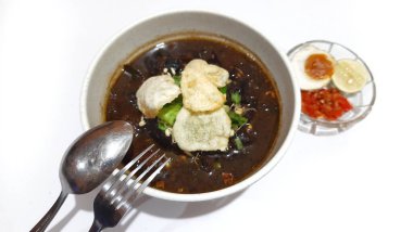 Rawon 'un beyaz kasede servis ettiği siyah et çorbası pırasa, fasulye filizi, tuzlu yumurta, limon, acı biber, kraker. Ponorogo, Doğu Java 'dan popüler Endonezya yemekleri