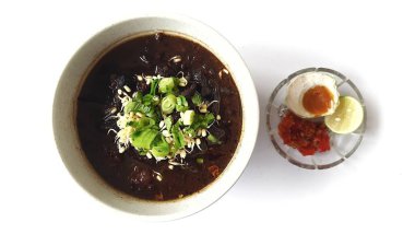 Rawon 'un beyaz kasede servis ettiği siyah et çorbası pırasa, fasulye filizi, tuzlu yumurta, limon, acı biber, kraker. Ponorogo, Doğu Java 'dan popüler Endonezya yemekleri