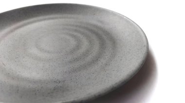 Beyaz arkaplanda izole edilmiş seramik melamin maddesi olan boş dairesel gri plaka