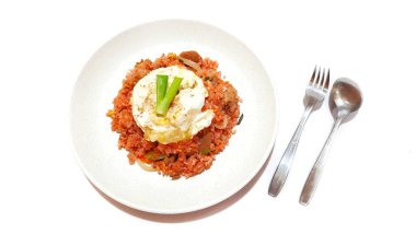 Beyaz tabakta servis edilen yumurta ve soğanlı kırmızı pilav.