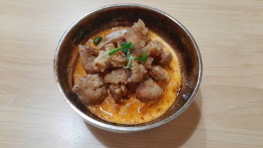 Mentai soslu tavuk karage pilavı, Tahta Masa 'da bir metal kasede servis ediliyor.