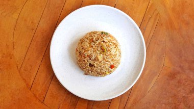 Beyaz arka planda izole edilmiş beyaz tabakta servis edilen deniz ürünleri pilavı. Gıda sunumu işi