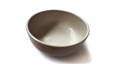 Beyaz zemin üzerinde seramik melamin maddesi olan boş yuvarlak kahverengi kase