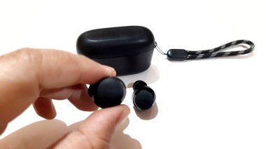 Kablosuz bluetooth kulaklıklar, hızlı şarj çantası beyaz arkaplanda izole edilmiş taşınabilir sesler.