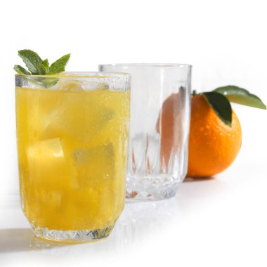 Bir bardak portakal suyu ve nane şekerli buz beyaz üzerine izole edilmiş.