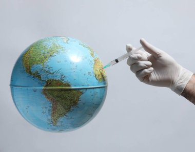 doctor holding globe with coronavirus covid - 19 vaccine on white background.