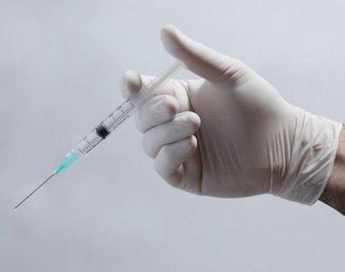Doktor el ele şırınga ile iğne, aşı konsepti