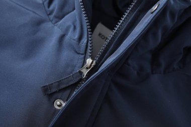 Geçmişi bulanık siyah bir ceketin dikey görüntüsü.