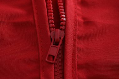 Kırmızı arka planda fermuarı olan kırmızı deri ceket.