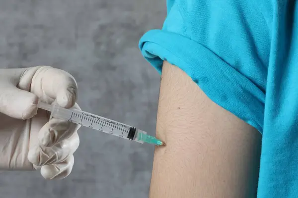 Eldivenli adam şırıngaya enjekte ediliyor.