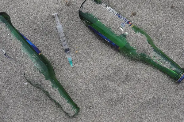 Sahilde şırınga ve bira şişesi