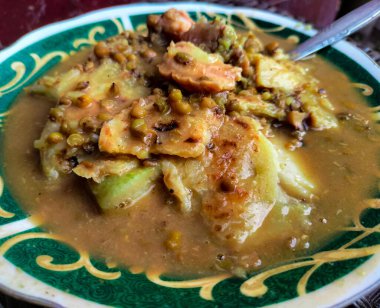 Geleneksel Endonezya tatlılarından Bubur Kacang Hijau, mung fasulyesi, hindistan cevizi sütü ve muzdan yapılmıştır. Yemek lezzetli ve lezzetlidir. Kaşık desenli bir kasede servis edilir..