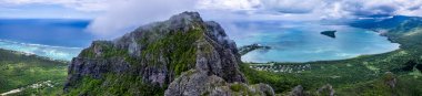 Dağların tepesindeki gökyüzü bulutlu ve yeşil ormanlı Le Morne Brabant Dağı, Mauritius. İHA 'dan ateşlenmiş..