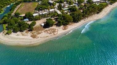 Nehir haliçli, yemyeşil yemyeşil ve dağ zeminli bir kıyı kasabasının havadan görünüşü.