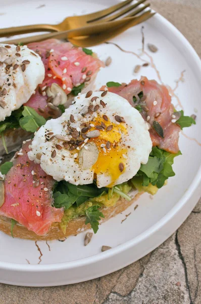 Somon balıklı bruschetta ve beyaz tabakta yumurta.