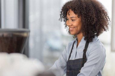 Afrikalı kadın kahve dükkanı küçük işletme sahibi tezgahın önünde durup stok kontrolü yapıyor. afro saç çalışanı Barista girişimci.